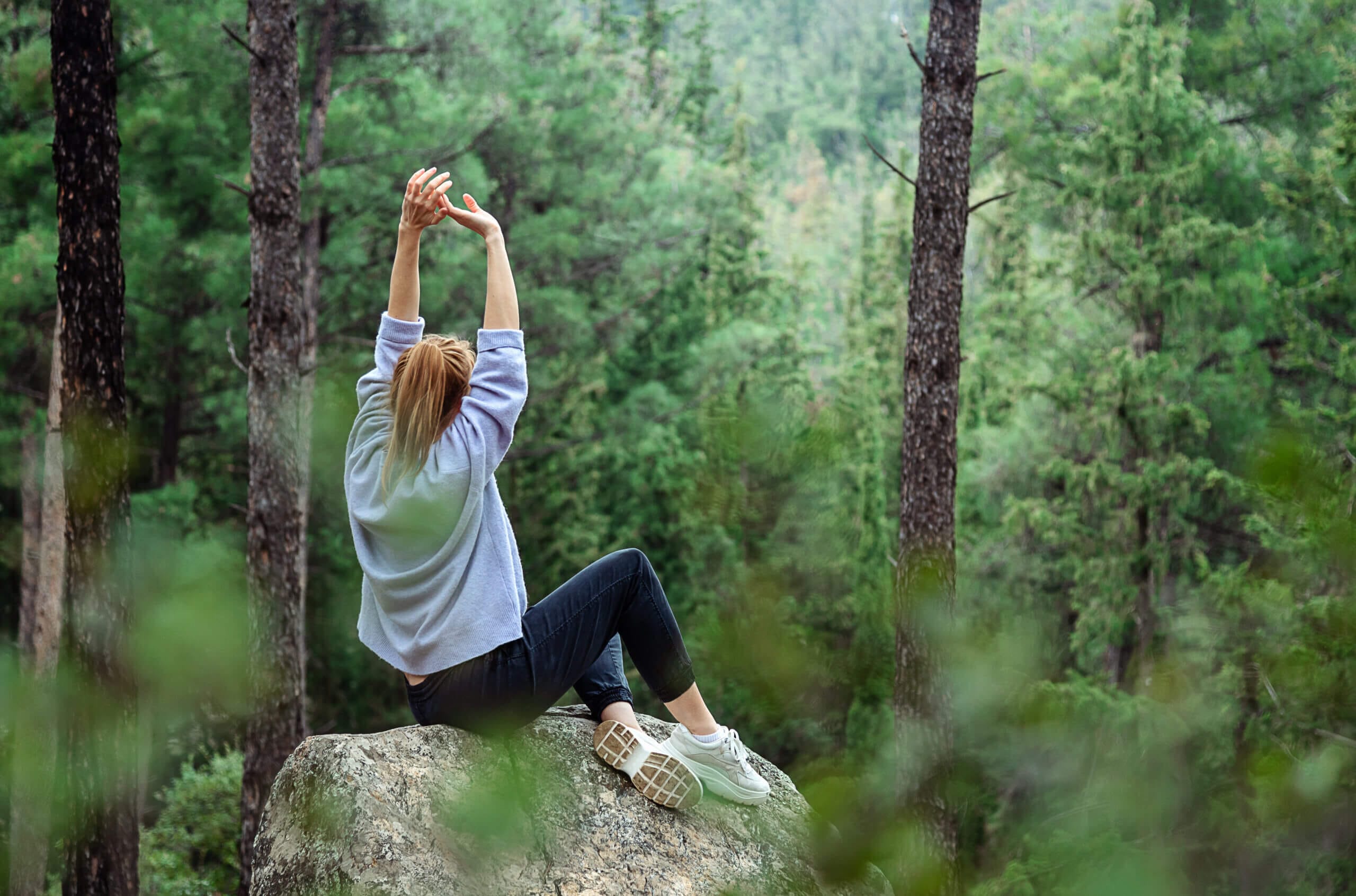 Eine Frau entspannt beim Waldbaden.